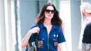 Anne Hathaway tampil mengenakan jumpsuit denim dengan aksen patch. Ia membawa Tas Valentino Garavani Panthea hitam yang  diperkenalkan dalam koleksi Fall Winter 2025/2026 bertajuk Le Méta-Théâtre Des Intimités oleh Creative Director Valentino, Alessandro Michele. [Dok. Valentino]