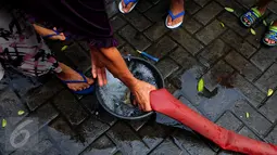 Warga mengisikan air ke dalam ember saat pembagian bantuan air bersih di Jalan Kakap Raya, Tanggerang, Senin (17/8/2015). Dalam beberapa hari terakhir, warga Tangerang dan sekitarnya kesulitan mendapatkan air bersih. (Liputan6.com/Faizal R Syam)