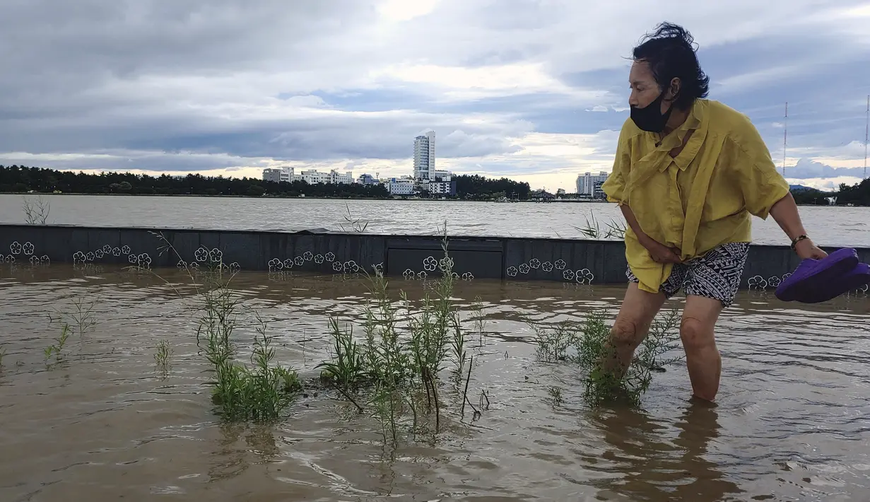 Seorang warga berjalan melewati area banjir di Gangneung, Korea Selatan, Kamis (3/9/2020). Topan Maysak saat ini sedang bergerak menuju ke sisi timur semenanjung ke Laut Jepang, yang dikenal sebagai Laut Timur di Korea, dengan kecepatan hingga 140 KM per jam. (Lee Hae-yong/Yonhap via AP)
