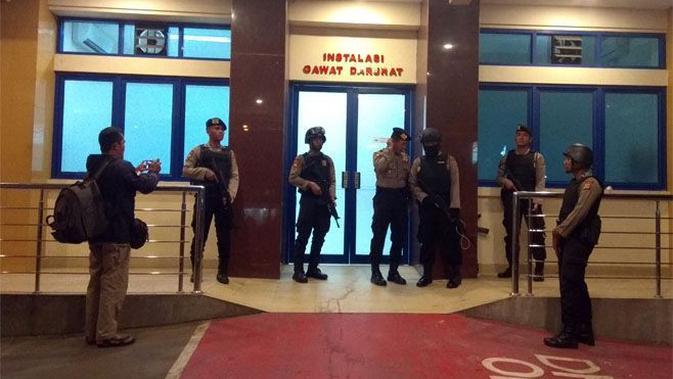 Pintu masuk IGD RS Mitra Plumbon Cirebon dijaga ketat anggota kepolisian bersenjata lengkap, Sabtu (25/8) dini hari. (Wildan Ibnu Walid/JawaPos.com)