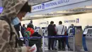 Wisatawan tiba untuk penerbangan di Bandara Internasional O'Hare di Chicago, pada 16 Maret 2021. Perjalanan udara di seluruh AS pulih dengan lebih cepat, terlihat dari semakin panjangnya antrean penumpang dan sibuknya lalu lintas transaksi tiket penerbangan online. (Scott Olson/Getty Images/AFP)