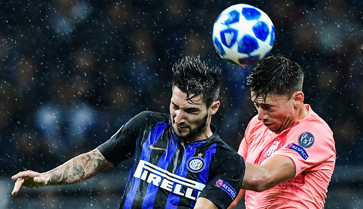 Gelandang Inter Milan, Matteo Politano, duel udara dengan bek Barcelona, Clement Lenglet, pada laga Liga Champions di Stadion San Siro, Milan, Selasa (6/11). Kedua klub bermain imbang 1-1. (AFP/Miguel Medina)