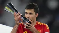 Rodri mencium trofi penghargaaan pemain terbaik Euro 2024 setelah membawa Spanyol menjuarai turnamen sepak bola Eropa di Spanyol itu, Senin (15/7/2024) dini hari WIB. (AP Photo/Manu Fernandez)