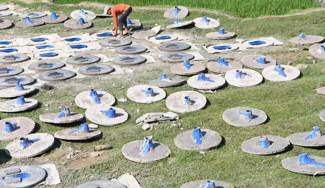 Seorang pria Bangladesh membuat cetakan untuk pembuatan toilet di Sonarpara, Cox's Bazar, Rabu (11/10). Pekerja di pabrik pembuat toilet harus bekerja ekstra agar dapat memenuhi permintaan dari kamp pengungsian Rohingya. (INDRANIL MUKHERJEE/AFP)