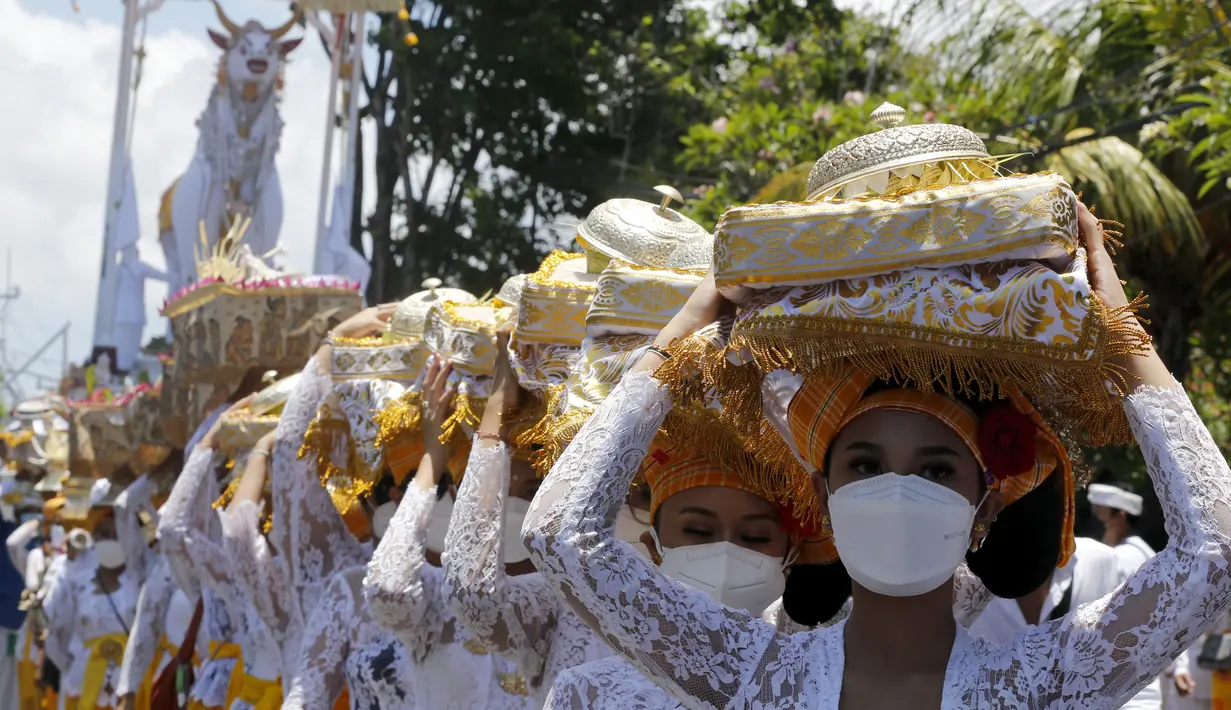 Perempuan Bali berbaris saat mereka membawa sesaji saat upacara Ngaben terhadap Ida Pedanda Nabe Gede Dwija Ngenjung di Denpasar, Jumat (8/10/2021). Upacara Ngaben itu sebagai penghormatan terakhir terhadap seorang pemuka agama Hindu di Bali. (AP Photo/Firdia Lisnawati)