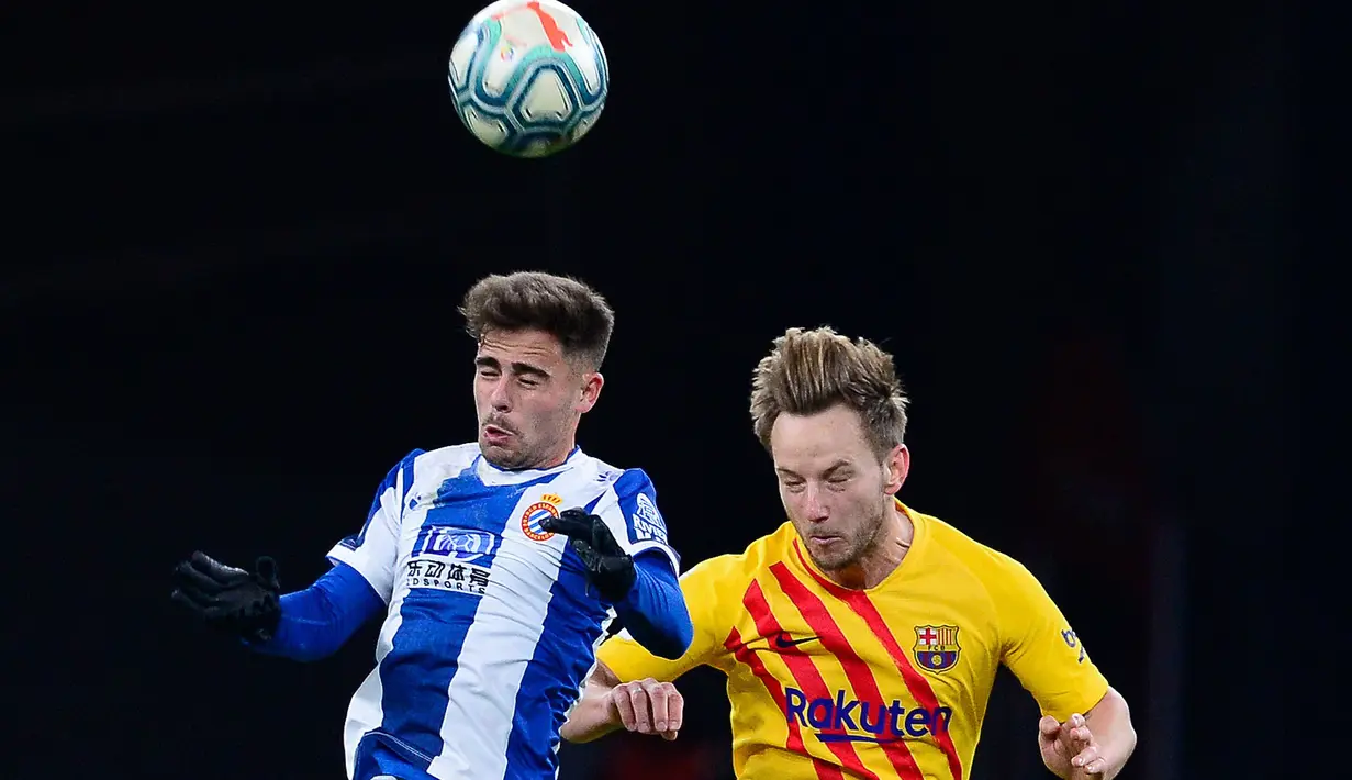 Gelandang Espanyol, Oscar Melendo berebut bola dengan gelandang Barcelona, Ivan Rakitic pada pekan ke-19 La Liga di RCDE Stadium, Sabtu (4/1/2020). Hampir saja menang, Barcelona harus puas menerima hasil imbang 2-2 atas Espanyol. (PAU BARRENA / AFP)