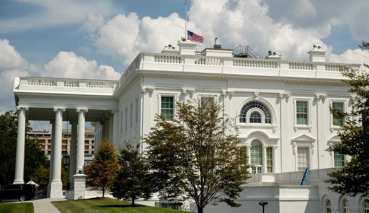 Pemandangan bendera nasional AS yang berkibar setengah tiang di Gedung Putih, Washington DC, Minggu (4/8/2019). Presiden Donald Trump memerintahkan bendera dikibarkan setengah tiang selama lima hari sebagai simbol dukacita atas dua penembakan massal di El Paso, Texas, dan Ohio. (AP/Andrew Harnik)