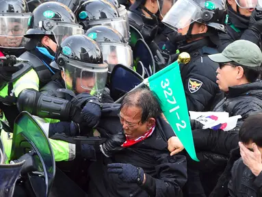 Pendukung Presiden Korea Selatan (Korsel), Park Geun-hye terlibat bentrok dengan aparat polisi di Seoul, Jumat (10/3). Pemakzulan Presiden Park yang dikeluarkan Mahkamah Konstitusi memicu aksi unjuk rasa yang berakhir bentrokan. (JUNG Yeon-Je/AFP)