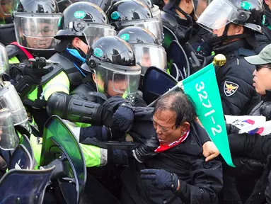 Pendukung Presiden Korea Selatan (Korsel), Park Geun-hye terlibat bentrok dengan aparat polisi di Seoul, Jumat (10/3). Pemakzulan Presiden Park yang dikeluarkan Mahkamah Konstitusi memicu aksi unjuk rasa yang berakhir bentrokan. (JUNG Yeon-Je/AFP)