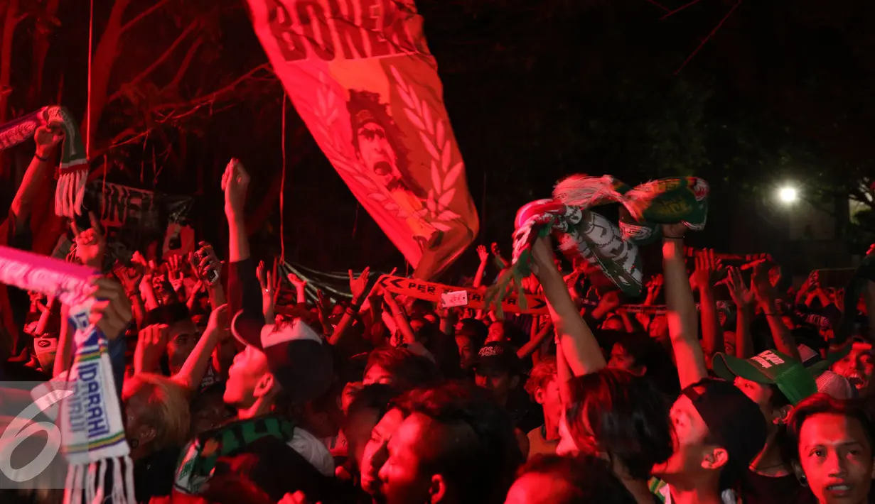Ratusan pendukung Persebaya bernyanyi menghabiskan malam di GOR Padjajaran, Bandung, Sabtu (7/1). Ribuan suporter Persebaya berkumpul di GOR Padjajaran menunggu keputusan kongres PSSI terkait nasib klub kesayangan mereka. (Liputan6.com/Helmi Fithriansyah)
