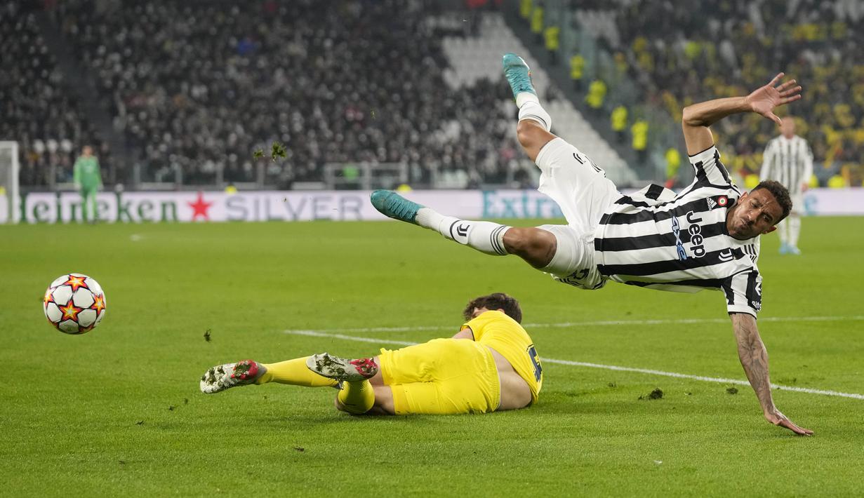 Bek Juventus, Danilo (kiri) ditekel pemain Villarreal Pau Torres pada pertandingan leg kedua babak 16 besar Liga Champions di stadion Allianz di Turin, Italia, Kamis (17/3/2022).  Dengan hasil ini, Villarreal berhak lolos ke babak perempat final Liga Champions. (AP Photo/Antonio Calani)