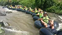 Salah satu rombongan pengunjung tengah menikmati sensasi river tubing di kawasan wisata air Sindangkasih, Cilawu Garut, Jawa Barat. (Liputan6.com/Jayadi Supriadin)
