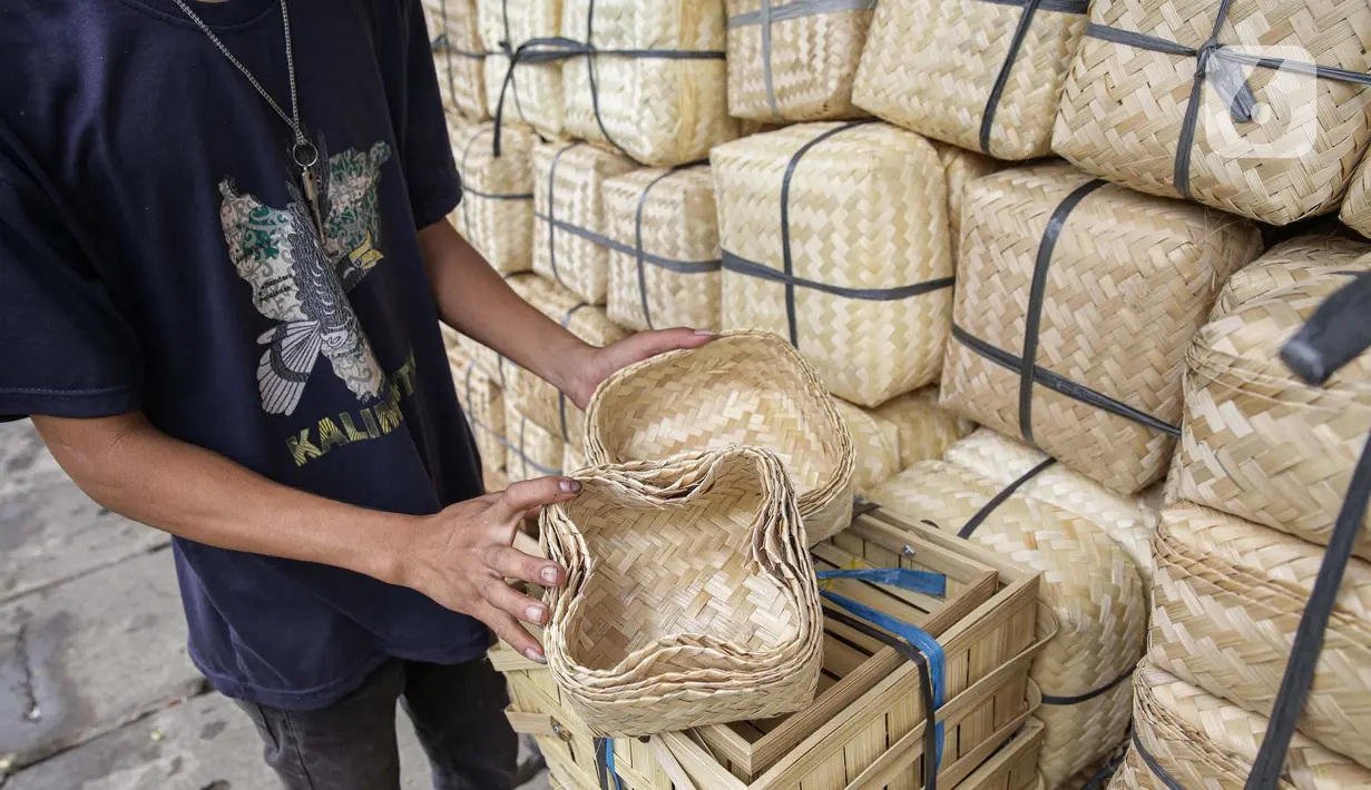 Pedagang menunjukkan besek dari anyaman bambu di Pasar Jatinegara, Jakarta, Kamis (1/7/2021). Harga satu besek dibandrol mulai dari Rp3.000 hingga Rp6.000 tergantung ukuran besek. (Liputan6.com/Faizal Fanani)