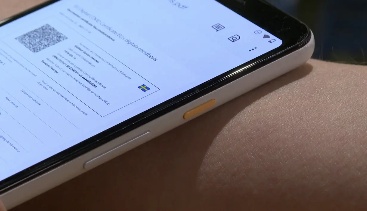 Direktur DSruptive Subdermals, Hannes Sjoblad memindai implan di lengan bawahnya dengan smartphone untuk mengungkapkan kartu kesehatannya di Stockholm (20/12/2021). Perusahaan Swedia DSruptive Subdermals telah membuat microchip sehingga pengguna dapat membawa paspor Covid. (AFP/Viken Kantarci)