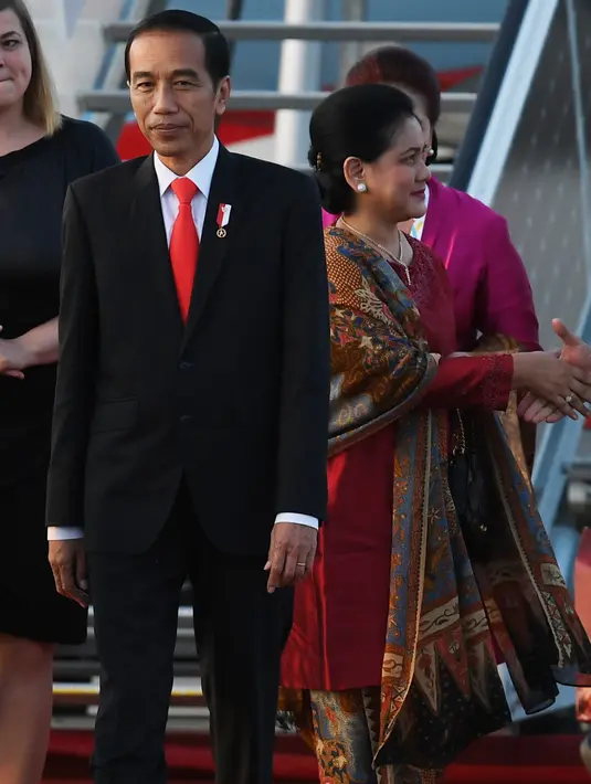 Presiden RI, Joko Widodo didamping Ibu Negara Iriana Widodo tiba di bandara Hamburg, Jerman utara (6/7). Sejumlah pemimpin negara berkumpul dalam KTT G20 pada 7-8 Juli 2017. (AFP Photo/Patrik Stollarz)