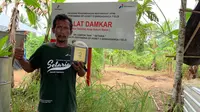 Sutrimo, Ketua Kelompok Setaria di Sangasanga, Kutai Kartanegara, Kalimantan Timur, memamerkan produk pupuk cair yang berasal dari inovasi DAMKAR, Alat Destilasi Asap Sekam Bakar.