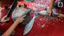 Pedagang memotong dan membersihkan sisik ikan bandeng dari air tambak di kawasan Rawa Belong, Jakarta, Rabu (10/2/2021). Menjelang perayaan Imlek atau Tahun Baru China, penjualan ikan bandeng tambak sepi pembeli akibat pandemi Covid-19 dibanding tahun sebelumnya. (Liputan6.com/Fery Pradolo)