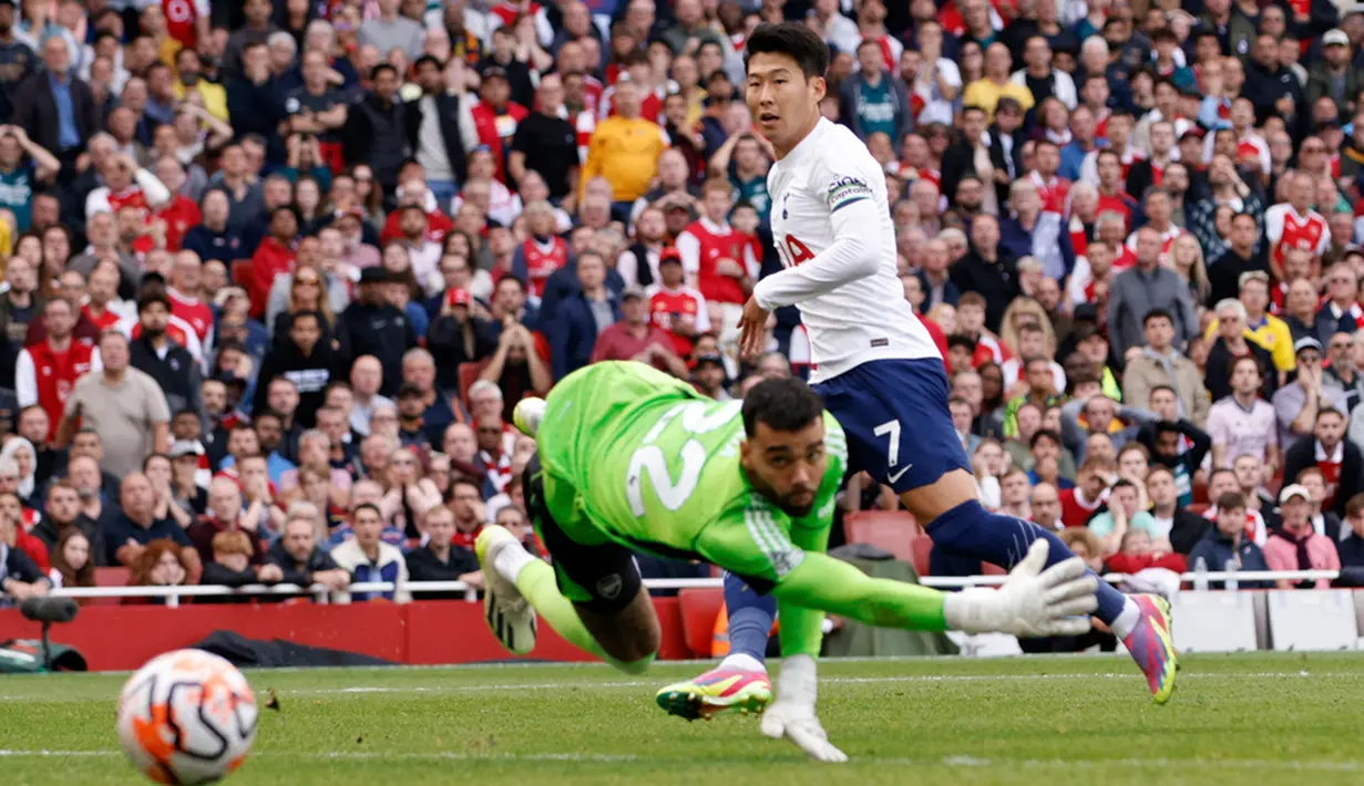 Pemain Tottenham Hotspur Son Heung-min mencetak gol ke gawang Arsenal yang dijaga oleh David Raya pada pertandingan sepak bola Liga Inggris di Emirates Stadium, London, Inggris, Minggu (24/9/2023). Pertandingan berakhir imbang dengan skor 2-2. (AP Photo/David Cliff)
