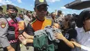 Petugas SAR membawa seorang anak  turun dari kapal pencarian dan penyelamatan di Pelabuhan Lembar, Lombok Barat, Rabu, 12 Agustus 2026. (AFP)