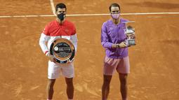 Pemenang Italia Terbuka 2021, Rafael Nadal dari Spanyol (kanan) dan juara kedua, Novak Djokovic dari Serbia berpose dengan trofi mereka usai turnamen tenis di Roma, Minggu (16/5/2021). Nadal mengalahkan Djokovic tiga set 7-5, 1-6, dan 6-3. (AP Photo/Gregorio Borgia)