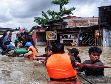 Para relawan membantu warga melewati derasnya banjir di Makassar pada 12 Februari 2025. (DAENG MANSUR/AFP)