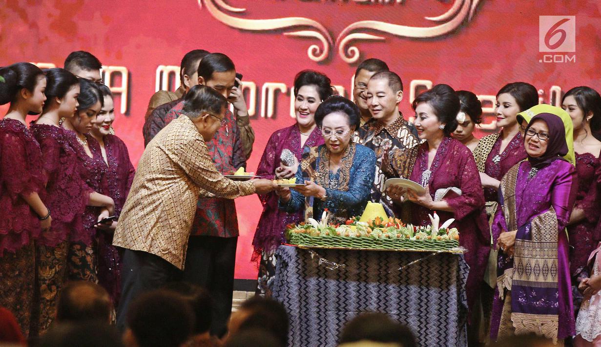 Pendiri PT Mustika Ratu Tbk, Mooryati Soedibyo memberi tumpeng ke Wakil Presiden Jusuf Kalla pada perayaan ulang tahunnya yang ke 90 di kawasan Gatot Subroto, Jakarta, Jumat (5/1). (Liputan6.com/Herman Zakharia)