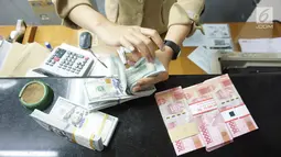Teller tengah menghitung mata uang dolar AS di penukaran uang di Jakarta, Rabu (10/7/2019). Nilai tukar rupiah terhadap dolar Amerika Serikat (AS) ditutup stagnan di perdagangan pasar spot hari ini di angka Rp 14.125. (Liputan6.com/Angga Yuniar)