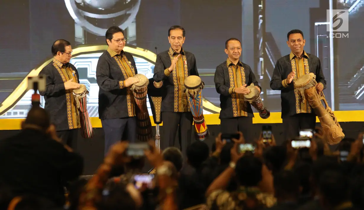 Presiden Joko Widodo (tengah) bersama Ketum Himpunan Pengusaha Muda Indonesia (HIPMI), Bahlil Lahadalia (kedua kanan) memainkan alat musik khas Papua selama Musyawarah Nasional XVI HIPMI di Hotel Sultan, Jakarta, Senin (16/9/2019). (Liputan6.com/Angga Yuniar)