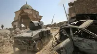 Kendaraan militer Irak melewati Masjid Agung al-Nuri yang hancur di Kota Tua di Mosul, 30 Juni 2017. Masjid yang dibangun pada abad ke-12 ini diledakkan ISIS pada 21 Juni 2017 sebagai upaya menghambat laju pasukan Irak. (AHMAD AL-RUBAYE/AFP)