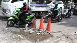 Pengendara menghindari jalan berlubang di kawasan Tanjung Barat, Jakarta, Rabu (30/1). Kondisi jalan rusak tersebut telah beberapa kali menyebabkan kecelakaan sehingga butuh penanganan. (Liputan6.com/Immanuel Antonius)
