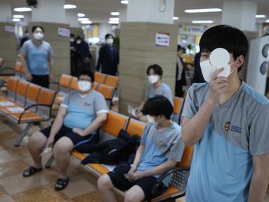 Seorang calon tentara Korea Selatan yang mengenakan masker tes mata saat menjalani pemeriksaan kesehatan untuk wajib militer di kantor Administrasi Tenaga Kerja Militer Seoul di Seoul, Senin (7/2/2022). (AP Photo/Ahn Young-joon)