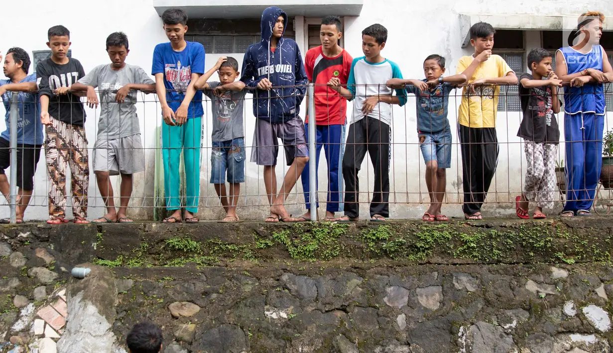 Warga melihat proses evakuasi KRL yang anjlok di kawasan Kebon Pedes, Bogor, Jawa Barat, Minggu (10/3). Penanganan KRL anjlok dilakukan dengan menggunakan crane yang didatangkan dari Bandung. (Liputan6.com/Immanuel Antonius)