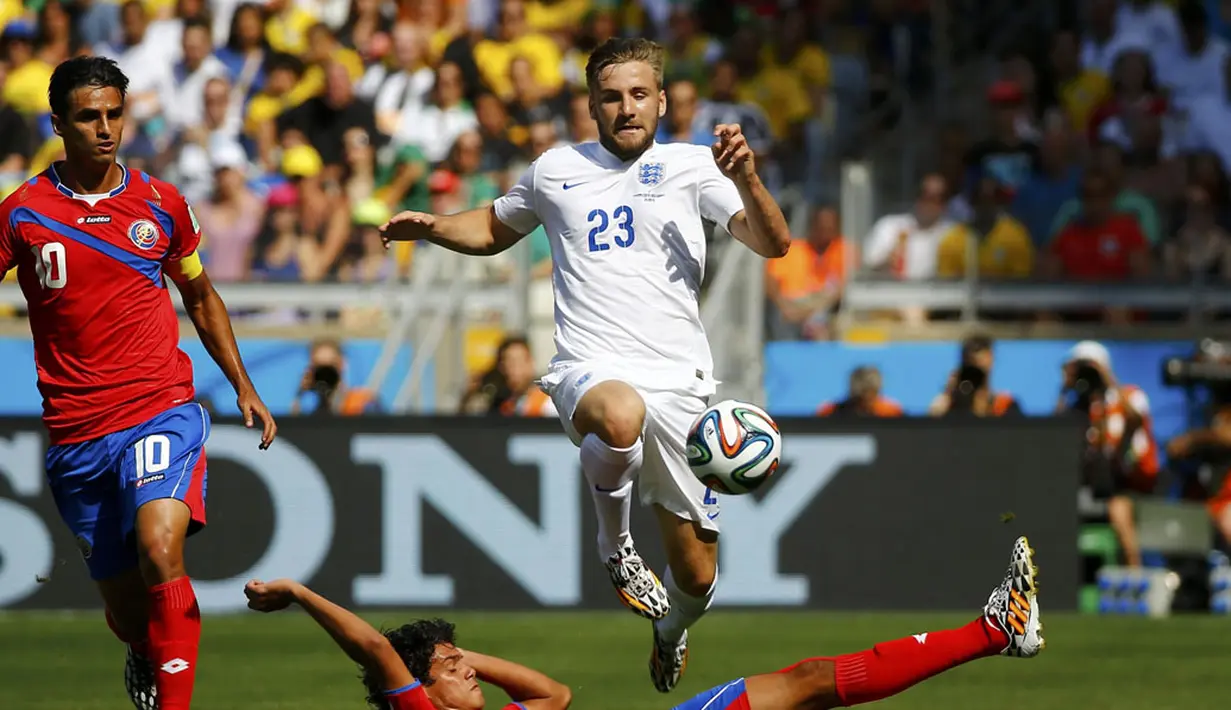 Pemain belakang Inggris, Luke Shaw (23) melompat menghindari tackling gelandang Kosta Rika, Michael Barrantes, di laga penutup penyisihan Piala Dunia 2014 Grup D di Stadion Mineirao, Belo Horizonte, Brasil, (24/6/2014). (REUTERS/Murad Sezer)