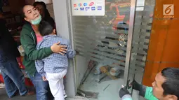 Murid TK, Fathur dipeluk ibunya saat tangannya terjepit kaca pintu ATM Bank BNI di Jalan M. Saidi, pesanggrahan, Jakarta Selatan, Senin (5/8/2019). Fathur terjepit pintu saat ibunya mengambil uang di ATM tersebut. (merdeka.com/Arie Basuki)