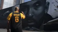 Erikk Aldridge merekam mural yang menggambarkan Kobe Bryant di Los Angeles, Rabu, 24 Agustus 2022.  Berukuran 125 kaki kali 32 kaki, mural tersebut menampilkan potret Bryant, yang meninggal pada tahun 2020 pada usia 41 tahun dalam kecelakaan helikopter. (AP Photo/Jae C. Hong)