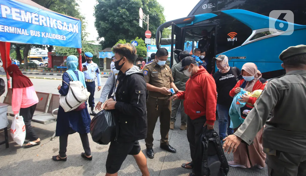 Petugas memeriksa suhu penumpang yang turun dari bus Antar Kota Antar Provinsi (AKAP) di Terminal bus Kalideres, Jakarta Barat, Senin (17/5/2021). Arus balik pemudik mulai terlihat di sejumlah terminal di Jakarta, salah satunya di Terminal Kalideres. (Liputan6.com/Angga Yuniar)