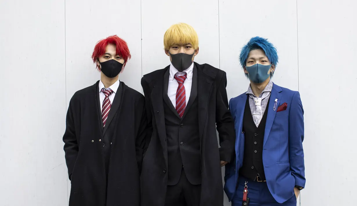 Tiga remaja berusia 20 tahun Hyoma Fukushima, Kaito Tani dan Shota Shimama (ki-ka) berpose mengenakan jas dengan rambut di cat selama upacara perayaan "Coming-of-Age Day" di Kawasaki, prefektur Kanagawa (11/1/2021). Acara ini digelar dalam keadaan darurat karena Covid -19. (AFP/Behrouz Mehri)