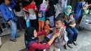 Seorang anak mencoba baju seragam sekolah di salah satu kios di Jalan Pengadilan, Bogor, Rabu (11/7). Menjelang dimulainya tahun ajaran baru, para orang tua disibukan belanja kelengkapan sekolah anak mereka. (Merdeka.com/Arie Basuki)