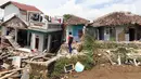 Warga melihat sejumlah rumah yang rusak akibat gempa di Desa Sarampad, Kabupaten Cianjur, Jawa Barat, Selasa (22/11/2022). Gempa dengan magnitudo 5,6 mengakibatkan sejumlah rumah dan jalan di Desa Sarampad rusak parah. (Liputan6.com/Herman Zakharia)