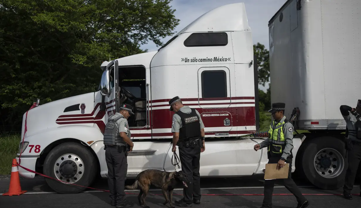 Agen imigrasi Meksiko dan anggota Garda Nasional menahan ratusan migran, sebagian besar dari Amerika Tengah.(AP Photo/Felix Marquez)