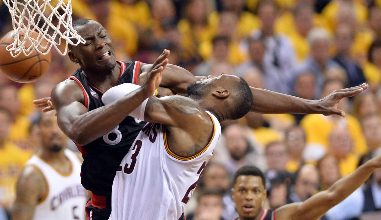 Pemain Cleveland Cavaliers, LeBron James, dihadang pemain Toronto Raptors, Bismack Biyombo, pada Final Wilayah Timur, NBA Playoffs 2016 di Quicken Loans Arena, Cleveland, Rabu (18/5/2016) WIB. Cavaliers menang 115-84. (Ken Blaze-USA TODAY Sports/Reuters)