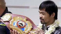Petinju asal Filipina, Manny Pacquiao melihat sabuk WBO  usai mengalahkan Timothy Bradley setibanya di Bandara Internasional Ninoy Aquino, Manila (14/4). (REUTERS/Romeo Ranoco)