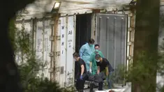 Petugas kesehatan memindahkan jenazah dari kontainer berpendingin ke mobil jenazah di lahan kosong dekat rumah duka di Hong Kong, Senin (7/3/2022). Kontainer berpendingin dijadikan tempat penyimpanan jenazah pasien Covid-19 dan jenazah lainnya akibat rumah sakit yang penuh. (AP Photo/Vincent Yu)