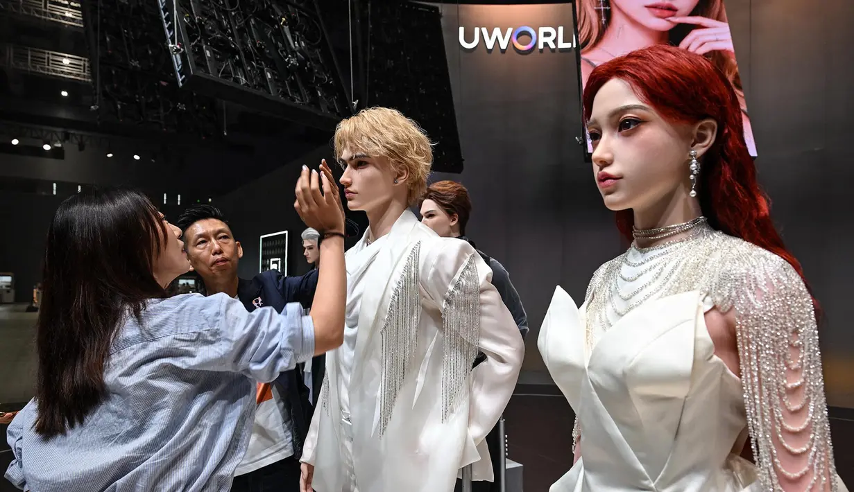 CEO UWORLD Michael Tam (kedua dari kiri) mempersembahkan robot humanoid kepada seorang pengunjung selama peluncuran robot humanoid U1 yang diproduksi oleh UWORLD, sebuah merek di bawah UBTECH Robotics, di Shenzhen, provinsi Guangdong, Tiongkok,  Selasa (30/06/2026). (AFP/ Adek Berry)