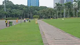 Petugas membersihkan taman di kawasan Monas, Jakarta, Rabu (23/1). Sejumlah taman di kawasan Monas rencananya akan ditata ulang. (Liputan6.com/Herman Zakharia)