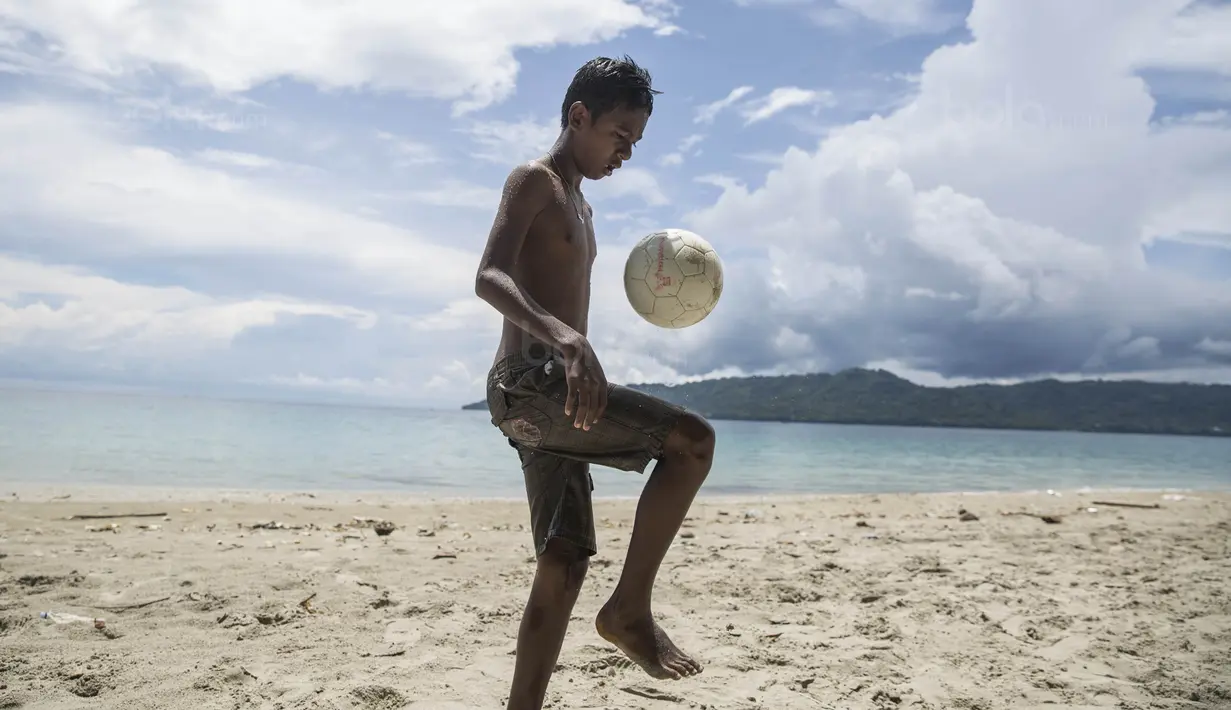 Pesepak bola SSB Tulehu Putra, Alghy Nahumarury, mengolah bola saat latihan di tepi Pantai Tial, Maluku, Rabu (16/11/2017). Dirinya merupakan salah satu pemain muda berbakat dari Negeri Tulehu. (Bola.com/Vitalis Yogi Trisna)