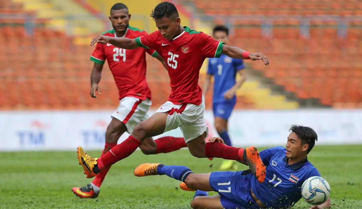 Bek Timnas Indonesia U-22, Osvaldo Ardiles Haay saat membawa bola dari kawalan pemain Thailand Rattanakorn Maikami saat bertanding di SEA Games 2017 di Shah Alam, Malaysia (15/8). (AP Photo / Vincent Thian)