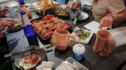 Pelanggan menikmat makanan di Ke'er restoran Ke'er di Beijing, China (26/5). Pemiliknya mengaku restoran yang dibuka belum setahun ini ramai dikunjungi yang mayoritas kaum anak muda. (REUTERS/Kim Kyung-Hoon)