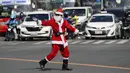 Petugas lalu lintas Filipina Ramiro Hinojas mengenakan kostum Sinterklas saat mengarahkan arus kendaraan di kota Pasay, Selasa, 5 Desember 2023. (AP Photo/Aaron Favila)