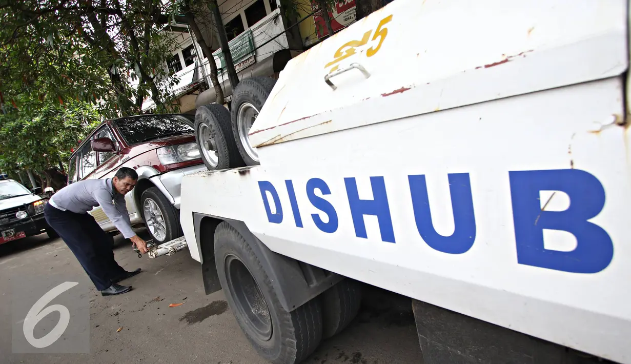Petugas Dinas Perhubungan DKI Jakarta melakukan razia parkir liar di kawasan Jatinegara, Jakarta, Senin (28/12). Meski sudah ditertibkan, pengendara masih tak menghiraukan peraturan tersebut. (Liputan6.com/Immanuel Antonius)